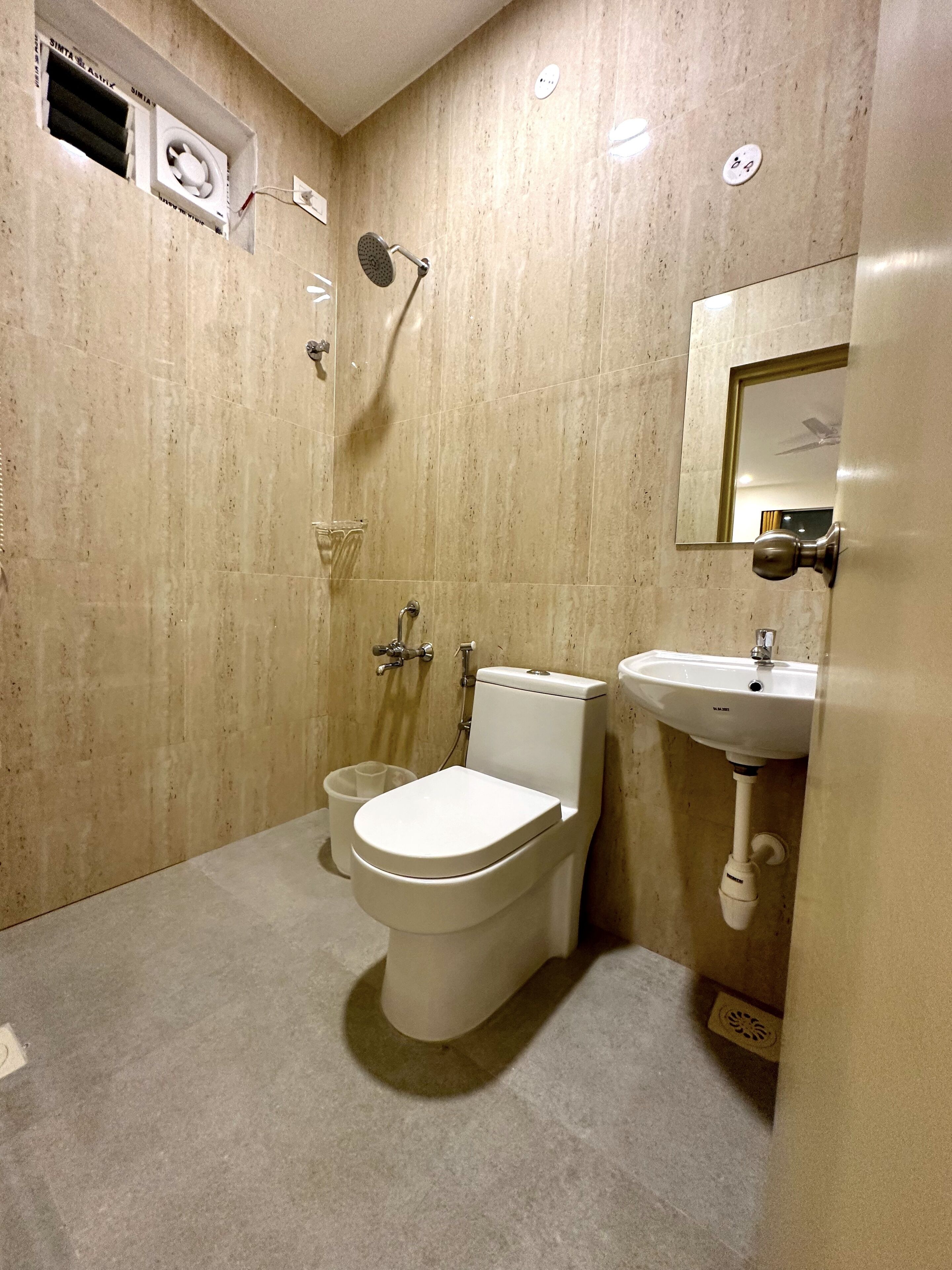 A modern bathroom with a toilet, sink, and shower.
