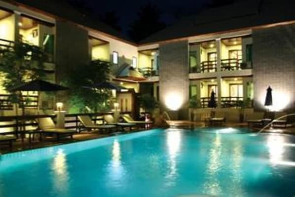 Una piscina al aire libre, sombrillas, sillones reclinables de piscina