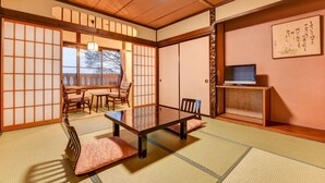 A traditional Japanese room with tatami flooring, a low table, and sliding doors. - Futarishizuka Hakuun (Takayama)