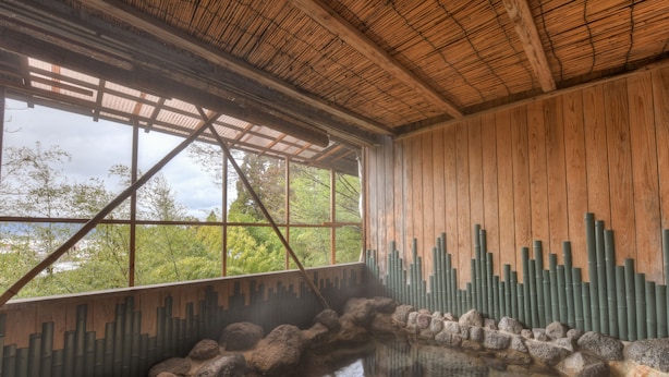 A traditional Japanese onsen with wooden walls, a rock-lined hot spring, and a bamboo backdrop. - Futarishizuka Hakuun (Takayama)