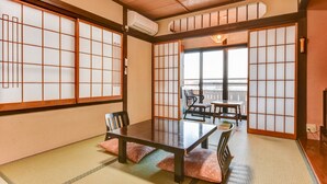 A traditional Japanese room with tatami flooring, a low table, and sliding doors. - Futarishizuka Hakuun (Takayama)