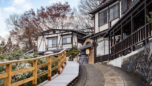 A traditional Japanese building with a wooden staircase leading to a wooden bridge. - Futarishizuka Hakuun (Takayama)