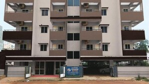 Un immeuble à plusieurs étages doté d’un atrium central, de balcons à chaque étage et d’une enseigne indiquant qu’il s’agit d’un hôtel.