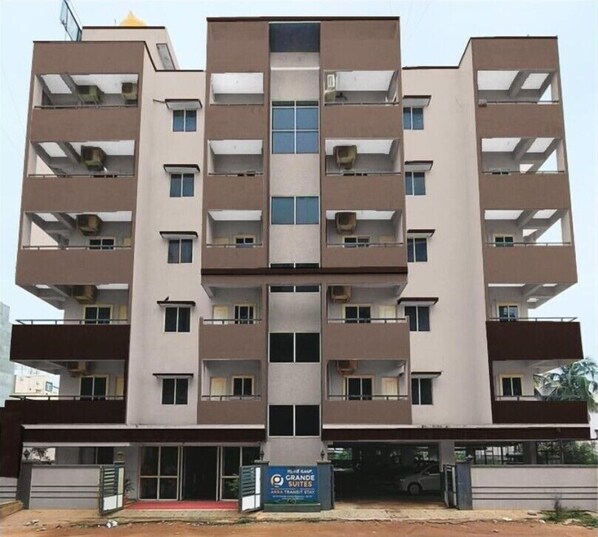 Un edificio de varios pisos con un atrium central, balcones en cada planta y un letrero que indica que es un hotel.