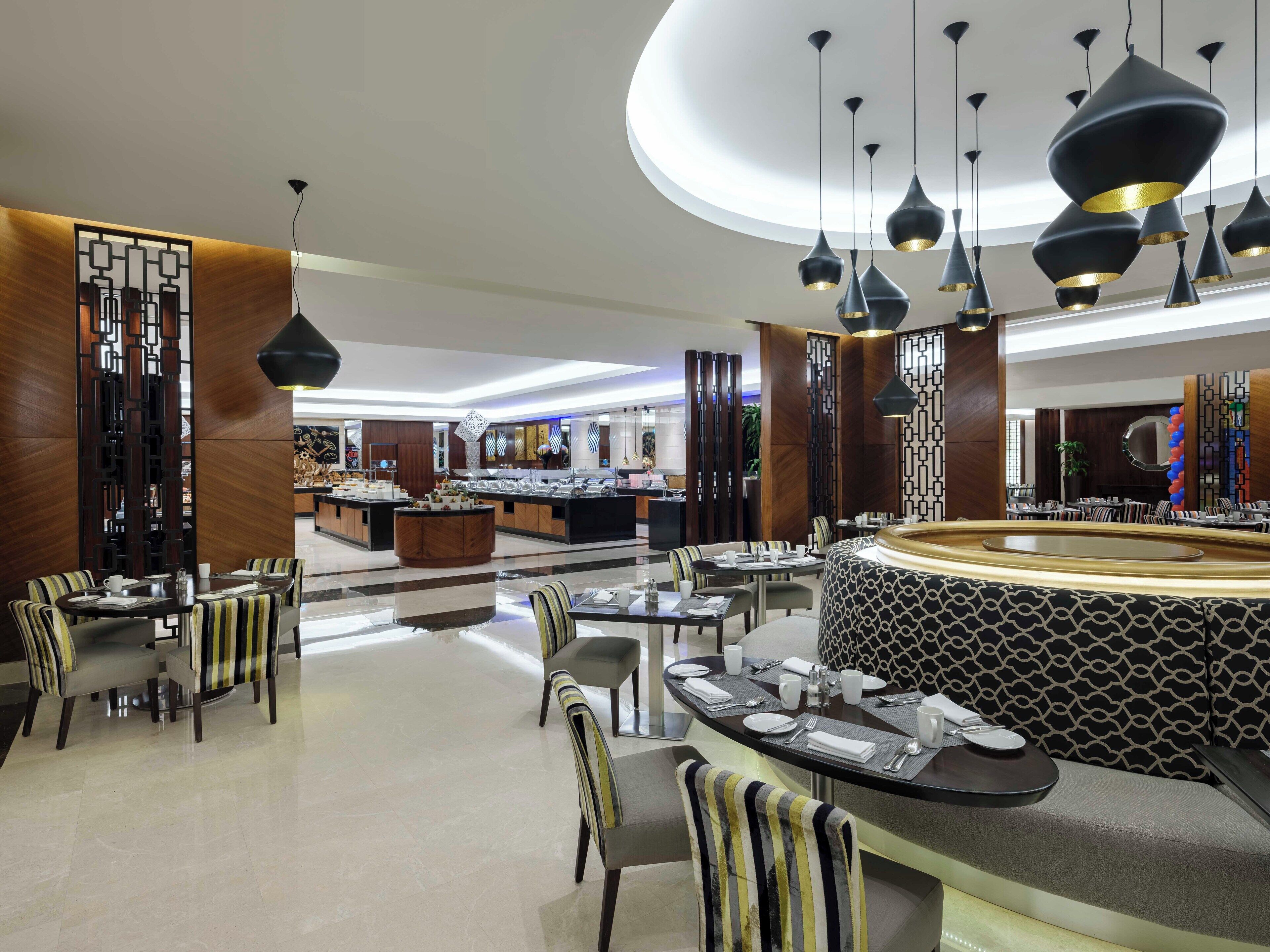 Un restaurante moderno con una isla central, sillas a rayas e iluminación colgante.
