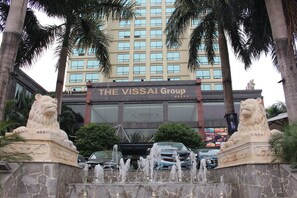 A building with a sign reading "THE VISSAI Group" and a fountain with lion statues in front. - The Vissai Hotel (Ninh Binh)