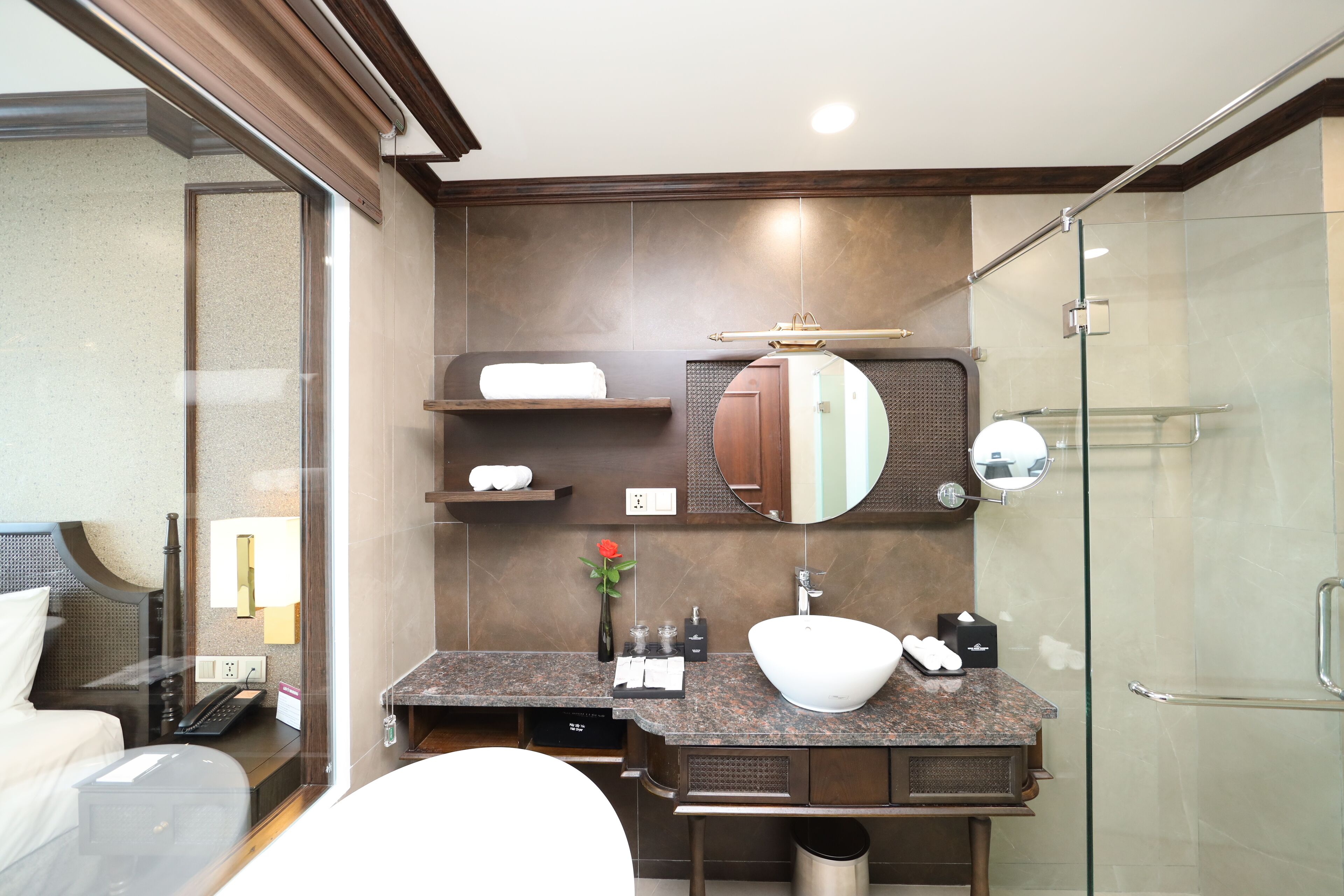 A modern bathroom with a large mirror, a vessel sink, and a shower area.