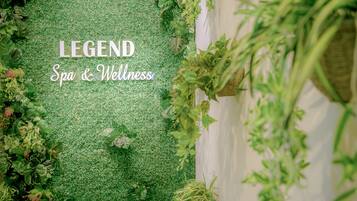 A green artificial grass area with the text "LEGEND Spa & Wellness" and surrounding plants.