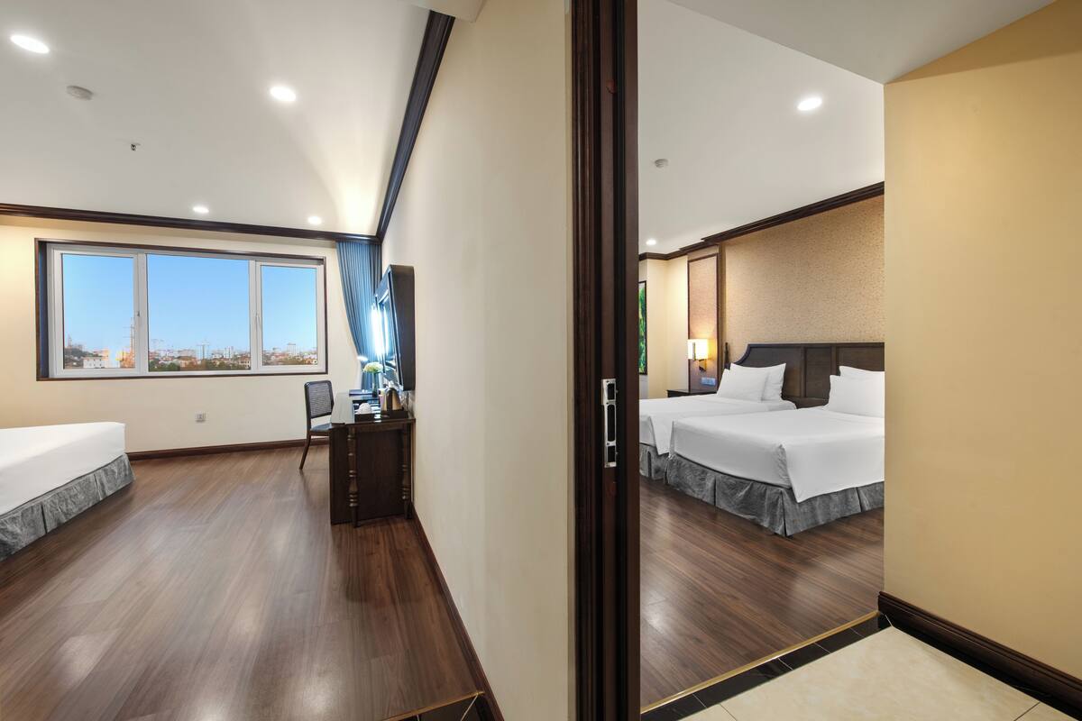 Een hotelkamer met een groot raam, een bed, een bureau en een stoel.