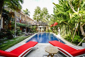 Alberca al aire libre y camastros 