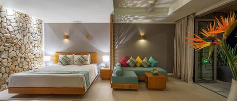 Una habitación de hotel moderna con pared de piedra, una cama grande, un sofá y vistas al exterior.