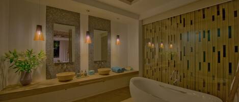 A modern bathroom with a freestanding bathtub, a large mirror, and a wooden panel wall.
