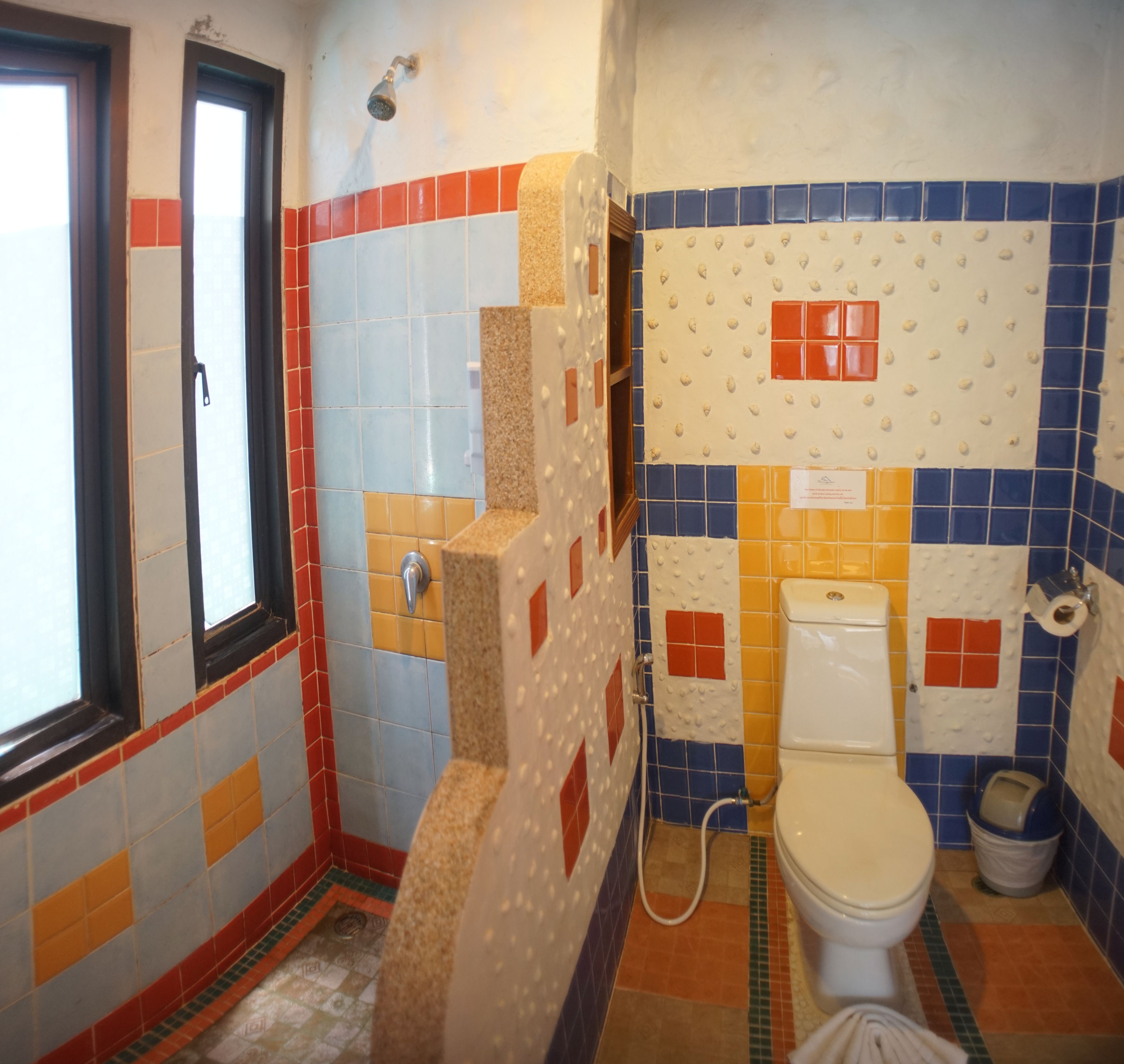 A bathroom with a toilet, shower, and sink.