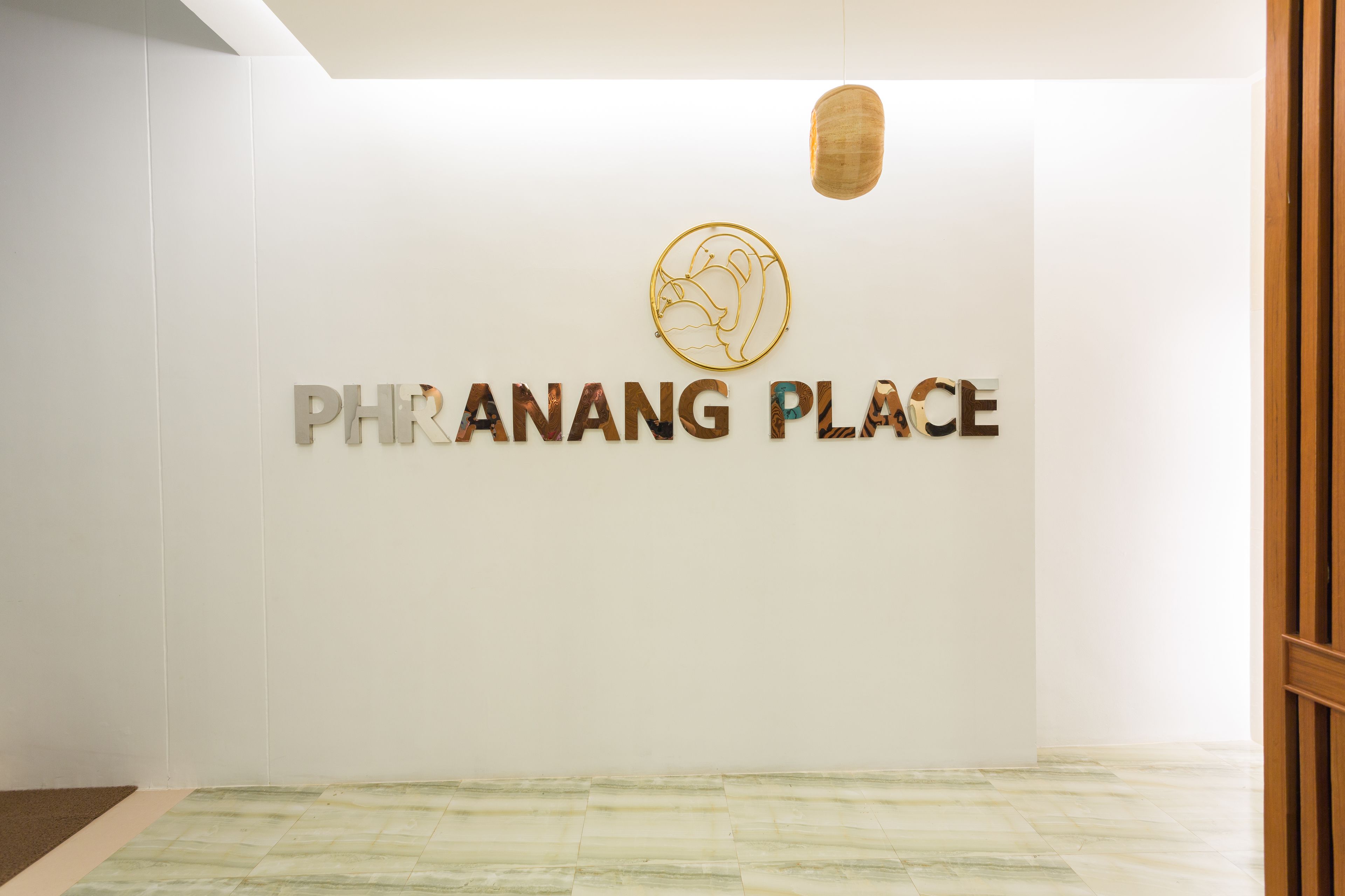 A clean, modern interior with a white wall and a logo above the text 'PHRANANG PLACE'.
