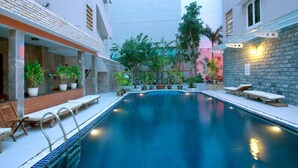 Una piscina amb gandules i plantes en testos.