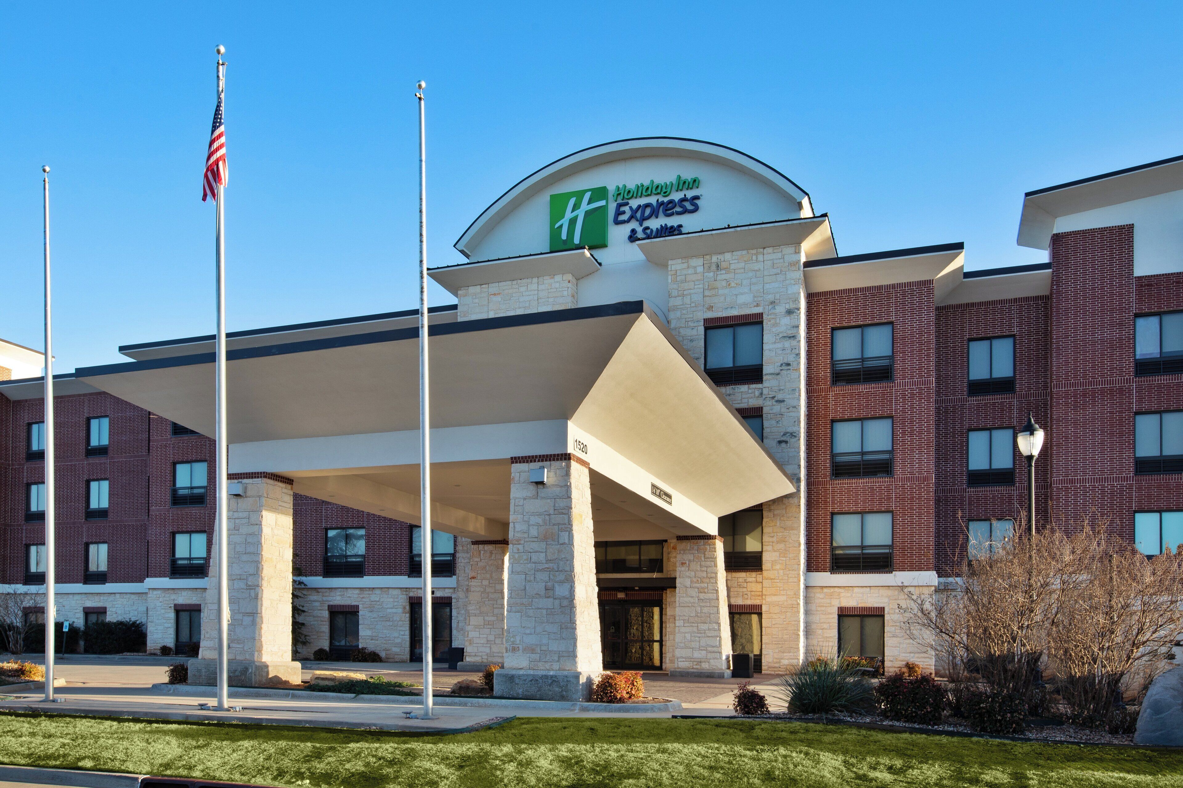 En Holiday Inn Express-byggnad med en fasad av tegel, en överbyggd entré och en amerikansk flagga.