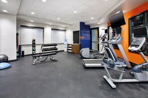 A gym with treadmills, elliptical machines, and free weights.