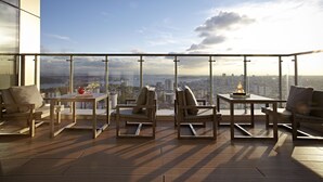 A balcony with wooden furniture and a city view. - Renaissance Istanbul Polat Bosphorus Hotel (Istanbul)