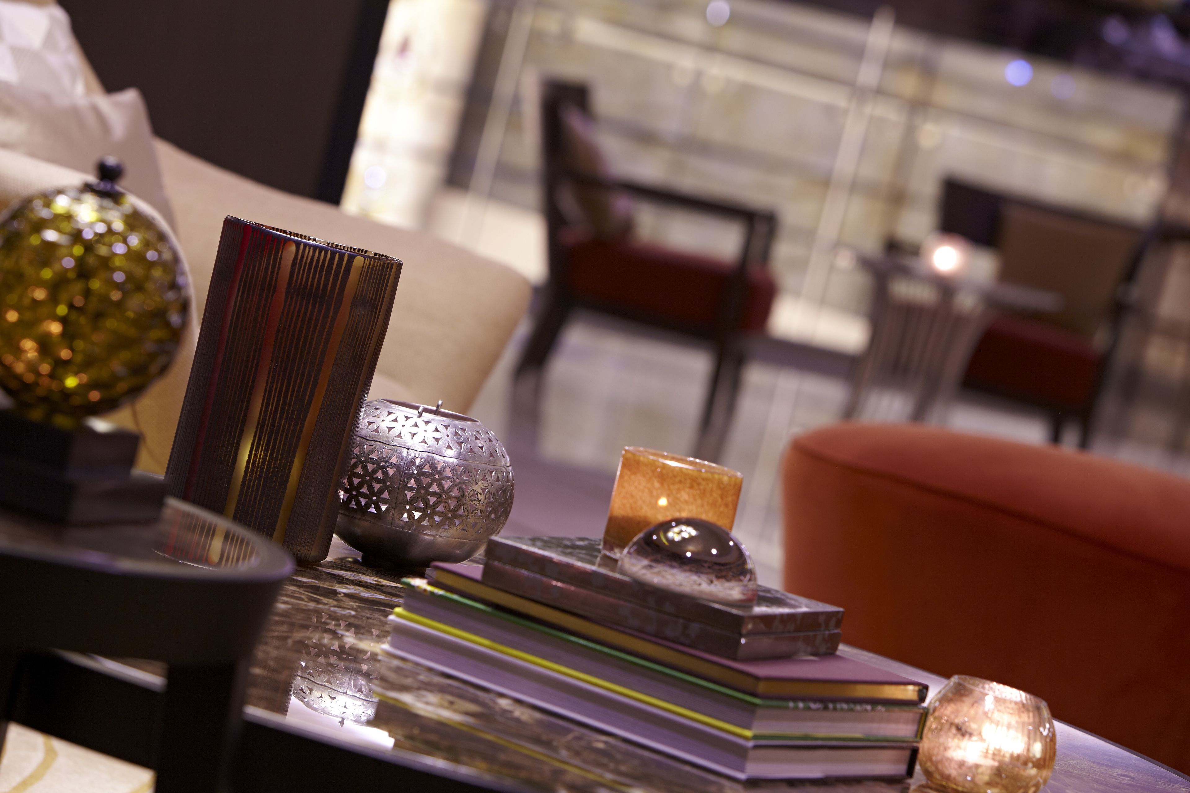 A neatly arranged table with books, a decorative bowl, and a candle.