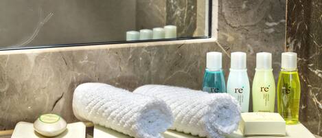 A bathroom vanity with a towel, soap, and toiletries.