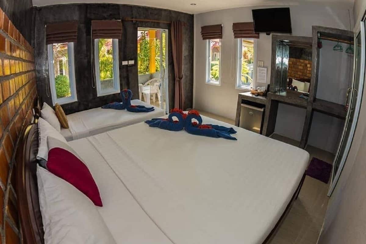 Une chambre d’hôtel avec deux lits, une télévision et une kitchenette.