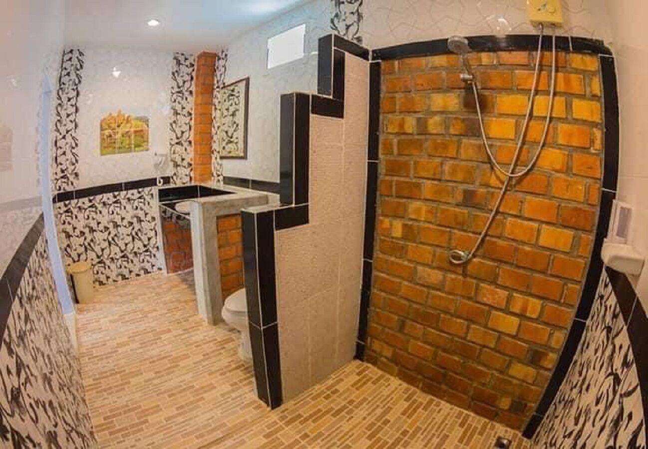 A bathroom with a shower, a toilet, and a sink.