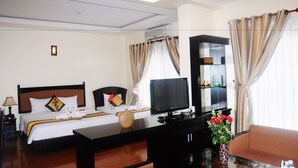 A hotel room with a bed, a TV, a desk, and a sofa. - Than Thien Friendly Hotel (Hue)