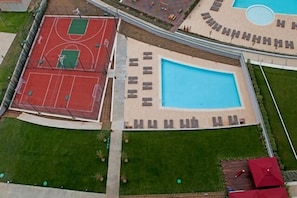 En säsongsöppen utomhuspool, parasoller och solstolar