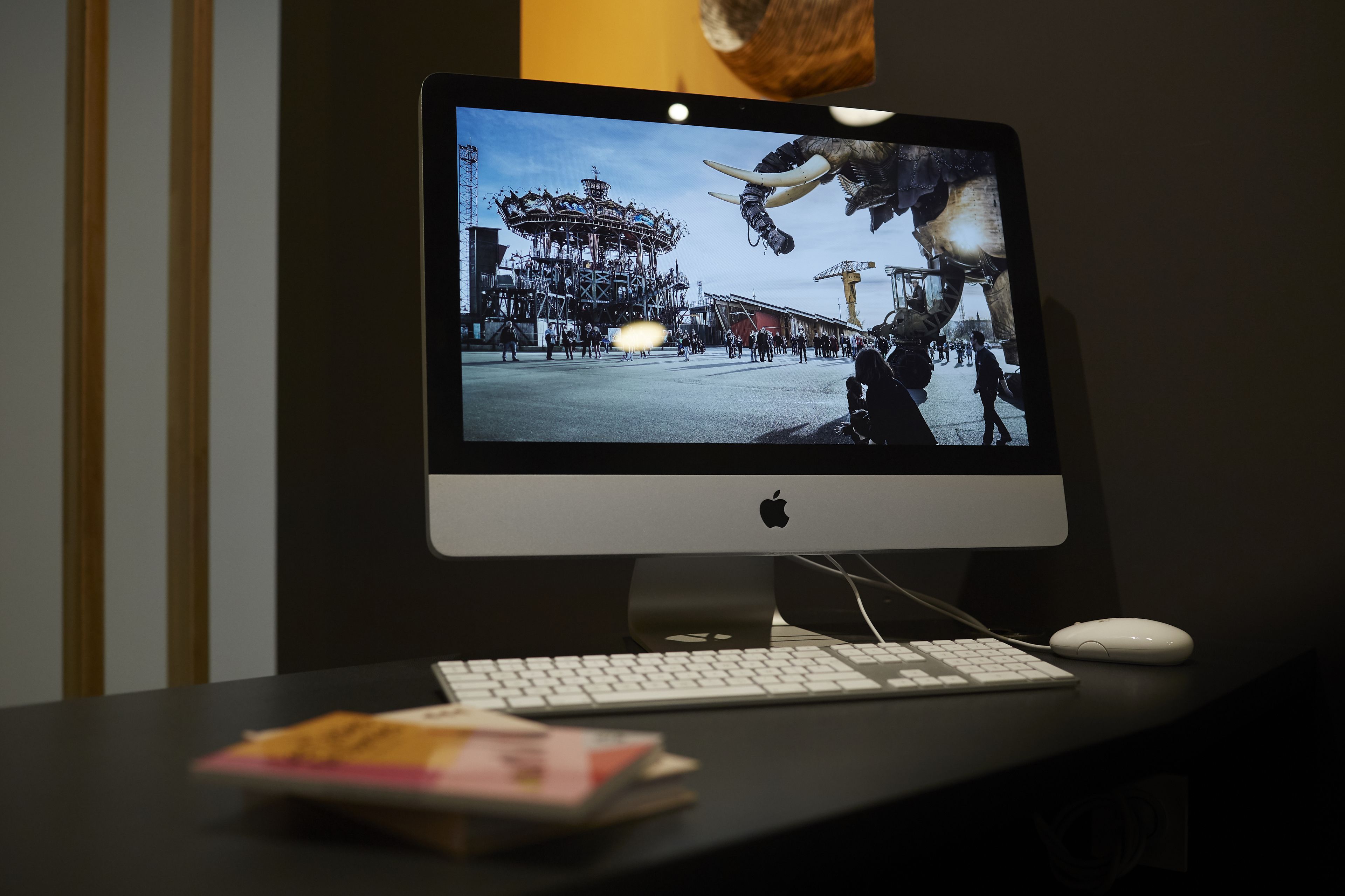 Una computadora de escritorio con monitor mostrando una escena, un teclado y un ratón sobre un escritorio.