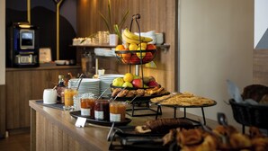 A buffet setup with fruits, pastries, and beverages. - Seven Urban Suites Nantes Centre (Nantes)