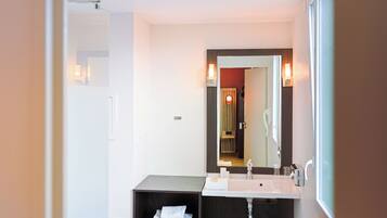 A modern bathroom with a dual sink vanity, a large mirror, and a towel rack.