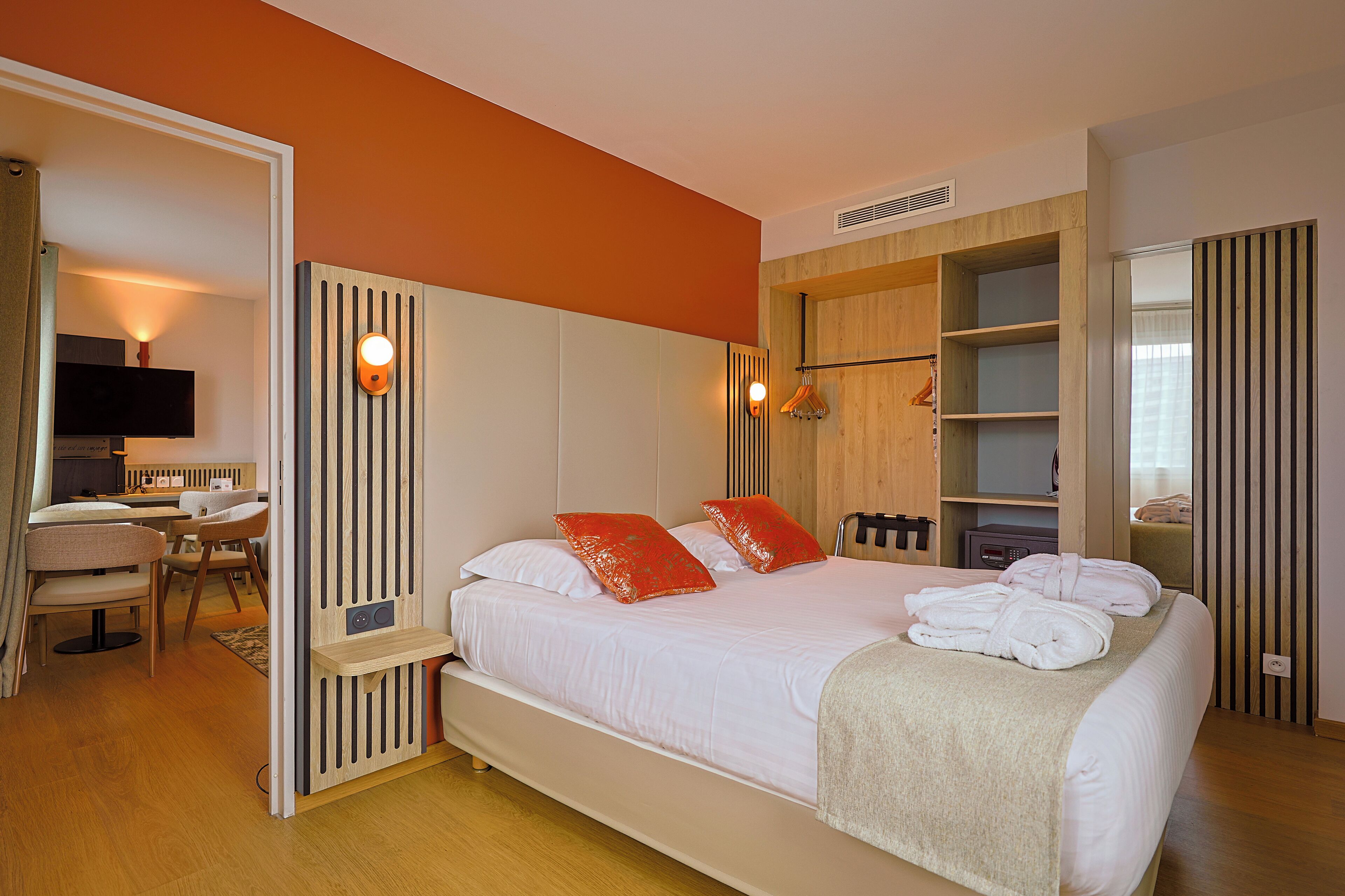 Une chambre d’hôtel avec un lit, un bureau et une télévision.
