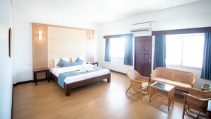 Een hotelkamer met een bed, een slaapbank, een kleine tafel en een stoel.