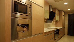 A modern kitchen with stainless steel appliances, wooden cabinetry, and a built-in oven.