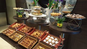 Un buffet proposant une variété de pâtisseries et de desserts présentés sur des présentoirs et dans des paniers.