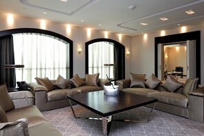 A modern living room with a sectional sofa, a coffee table, and a patterned carpet.