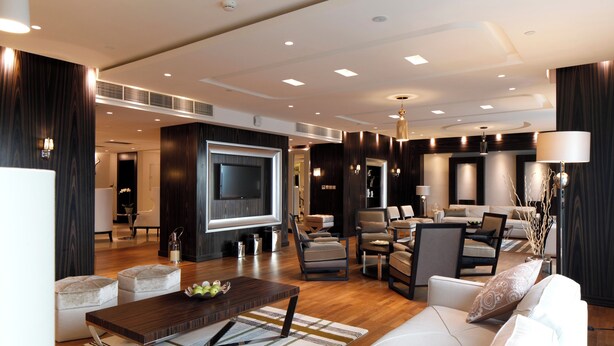 A modern living room with a flat-screen TV, comfortable seating, and a coffee table.