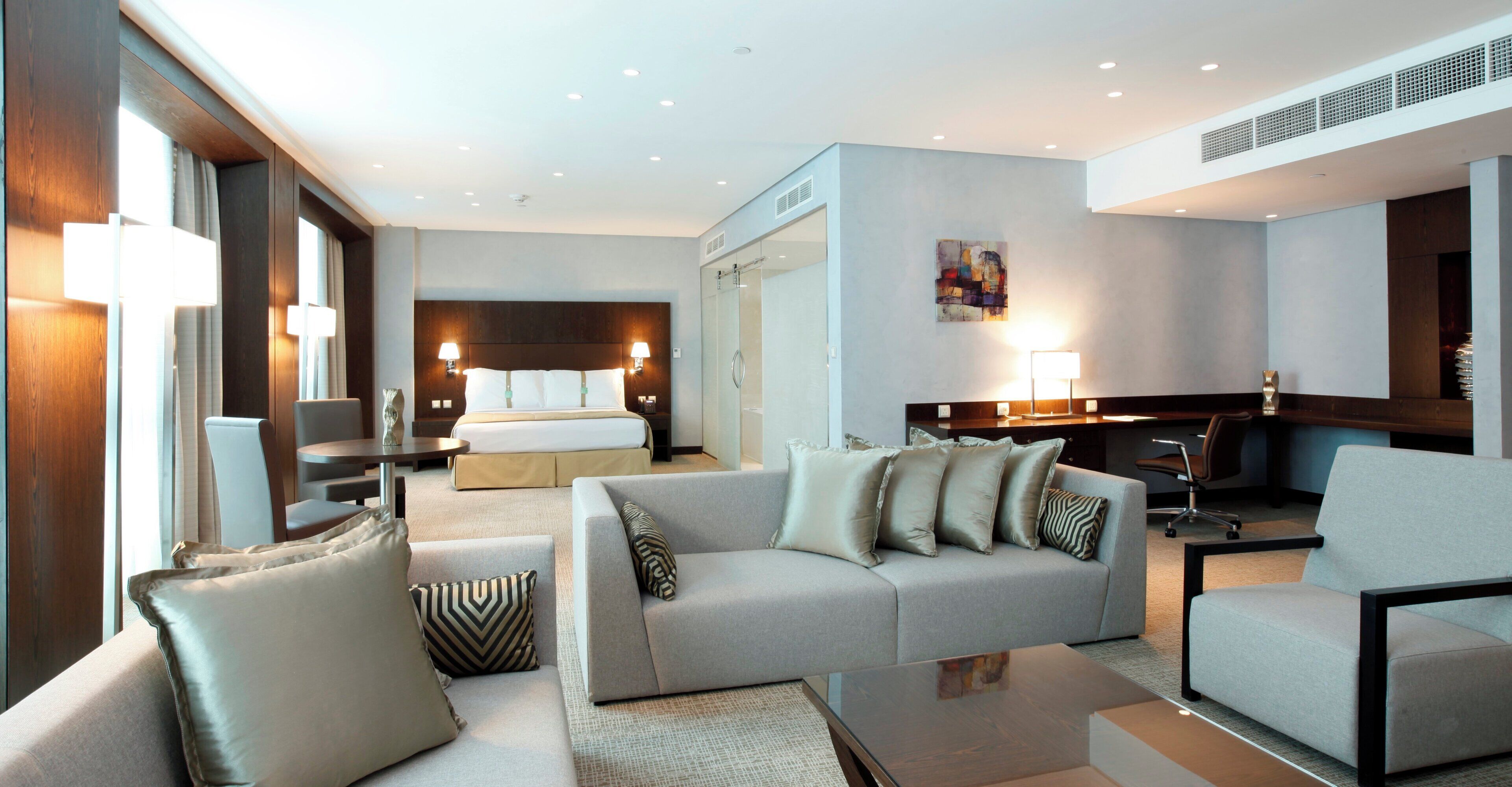 Una habitación de hotel con cama, sofá, escritorio y silla.