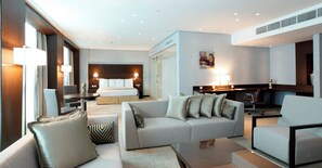 Een hotelkamer met een bed, een slaapbank, een bureau en een stoel.