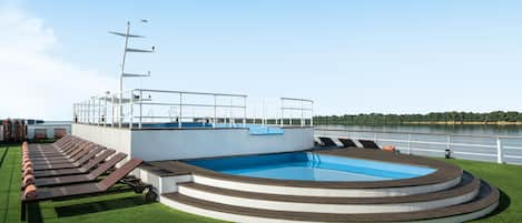 Una piscina al aire libre, tumbonas