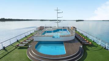 Alberca al aire libre y camastros