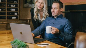 A room with a wooden table, a laptop, a white mug, and a potted plant. - Mountain Side Hotel Whistler by Executive (Whistler)