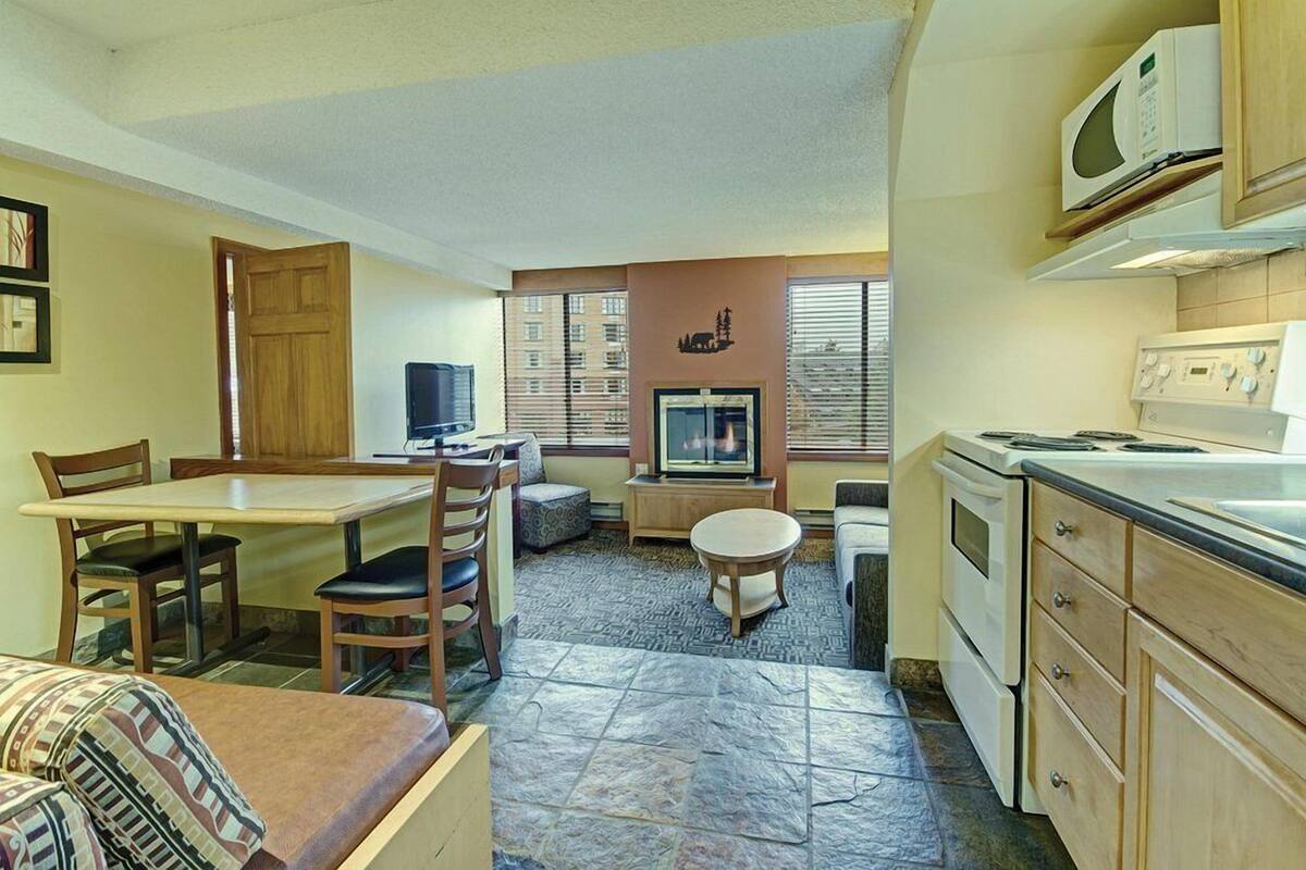 Un espacio habitable compacto con comedor, kitchenette y televisor.