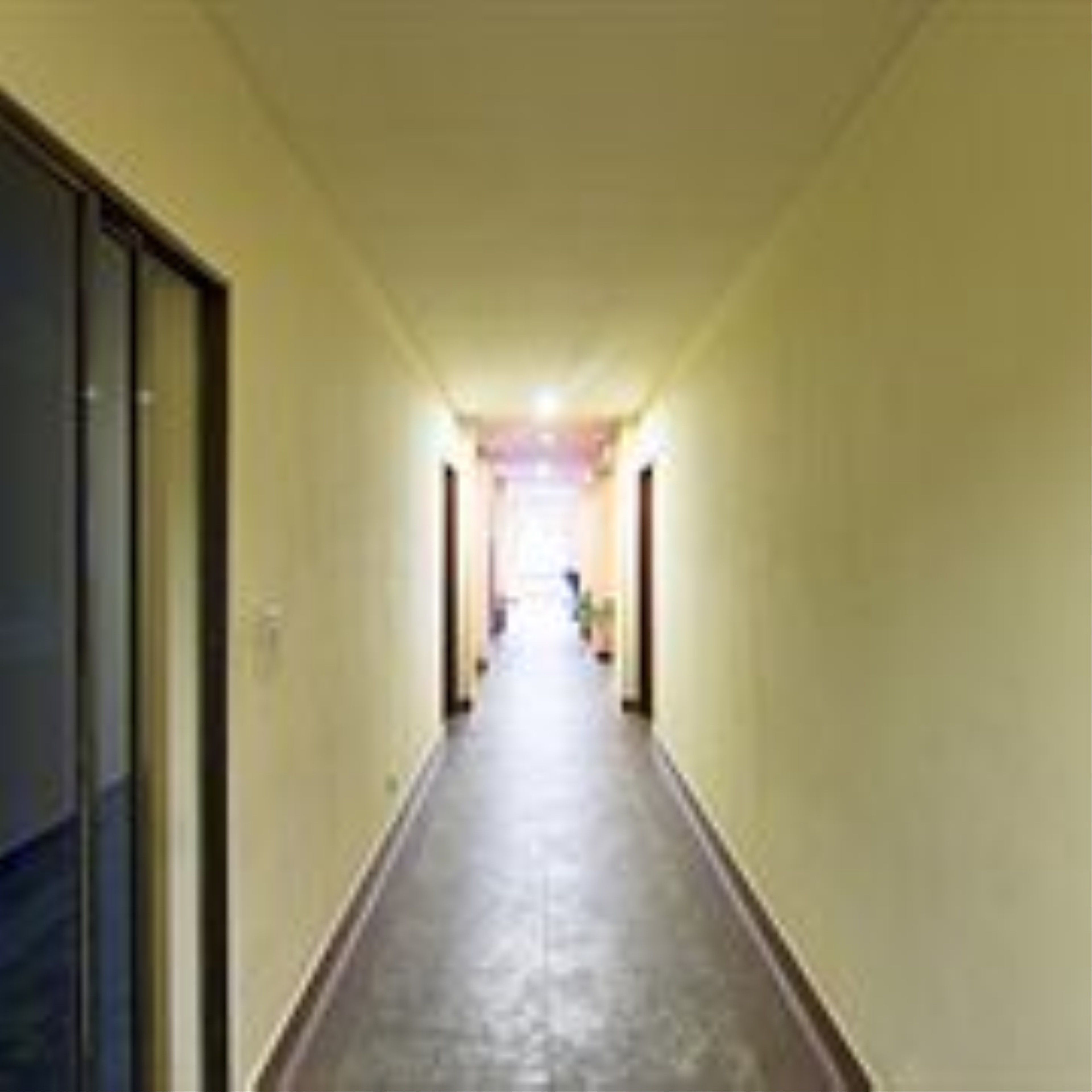 A long, narrow hallway with a polished floor and light-colored walls.