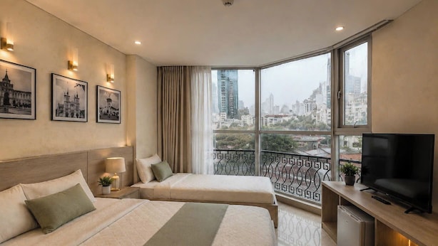 A hotel room with two beds, a TV, a mini-fridge, and a balcony with a city view. - Hikari Stay - Bui Vien CBD (Ho Chi Minh City)