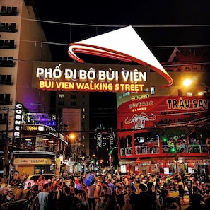 A busy street scene with illuminated signs, including 'PHÒ DI BÒ BÙ VIÊN' and 'BUI VIÊN WALKING STREET'. - Hikari Stay - Bui Vien CBD (Ho Chi Minh City)