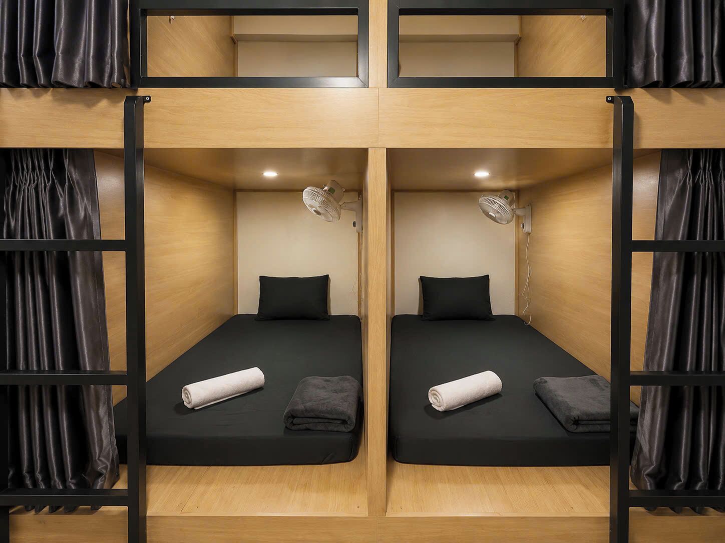 A bunk bed room with two beds, each with a pillow and a rolled towel.