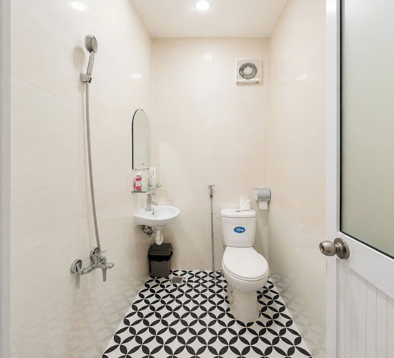 Un baño pequeño con inodoro, lavamanos y ducha.