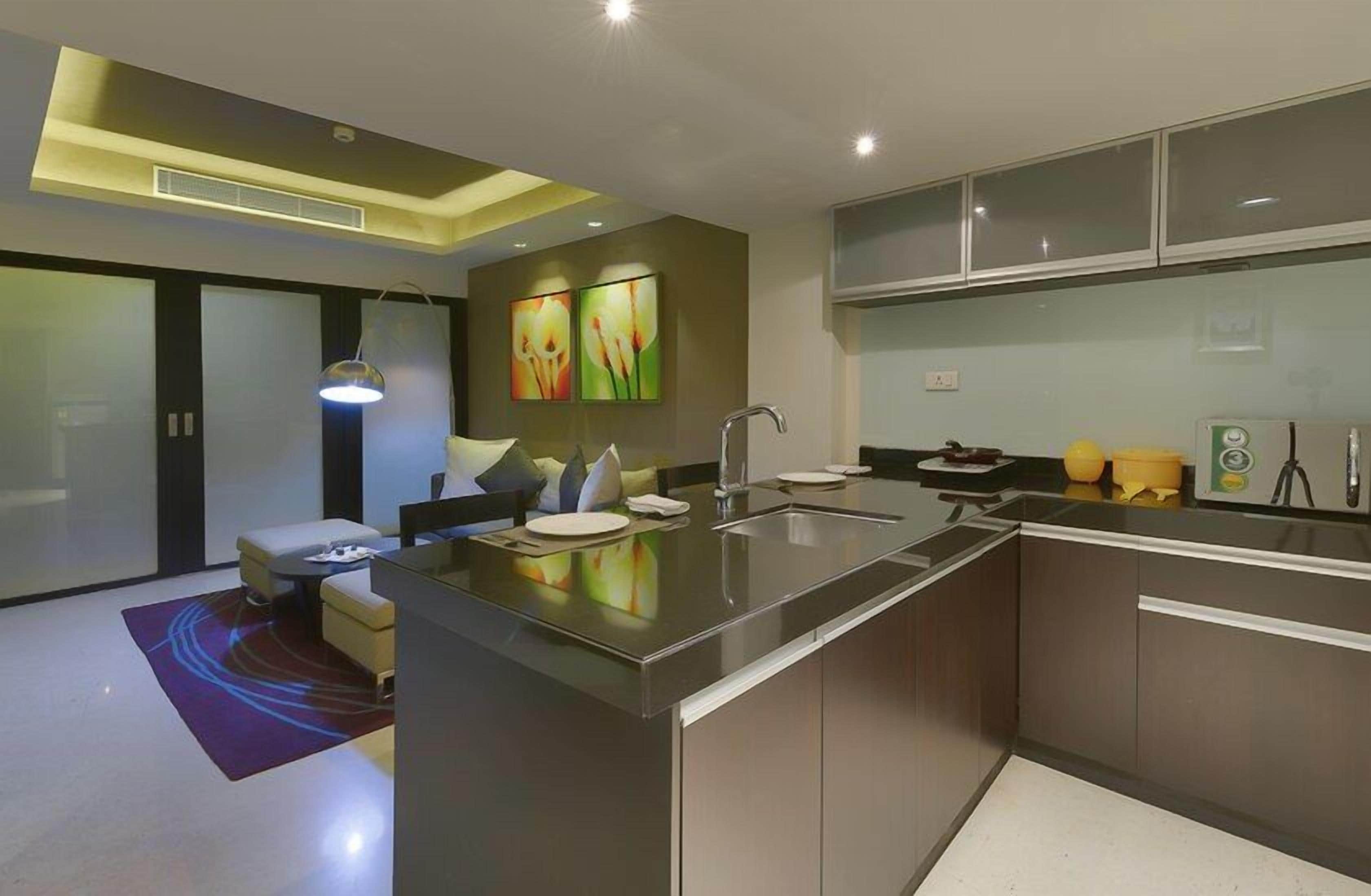 A modern kitchen with a central island, built-in appliances, and a dining area with a sofa and table.