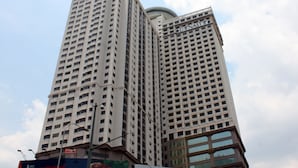 Un grand immeuble moderne, doté d’une façade à motifs géométriques et d’une enseigne bien visible sur le toit.